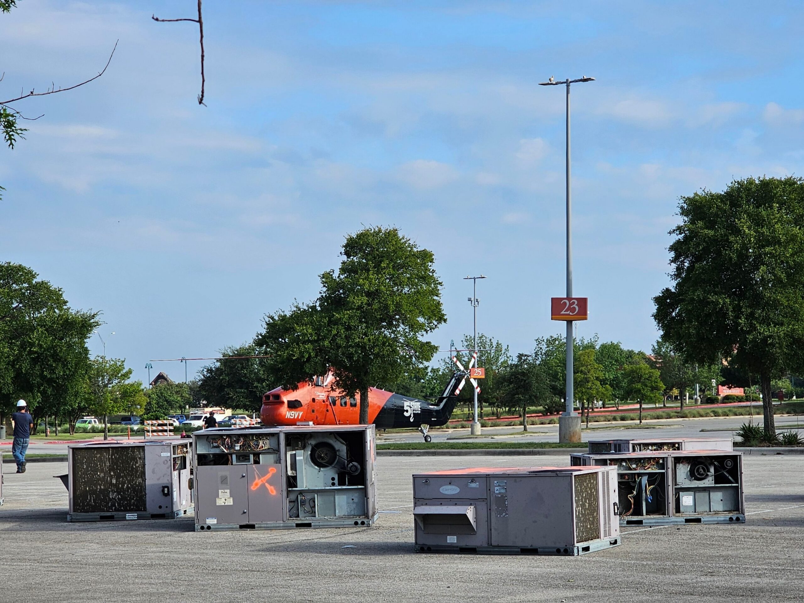 Multiple commercial HVAC rooftop units staged in parking lot ready for helicopter lift installation in DFW