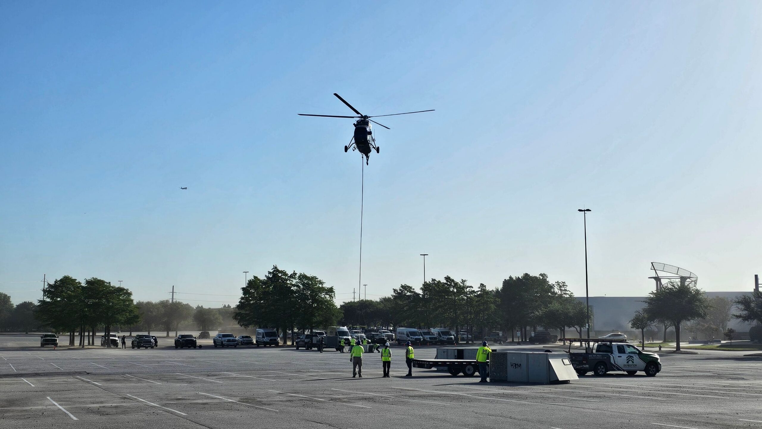 Expedition HVAC team in safety gear overseeing large commercial HVAC helicopter installation in DFW